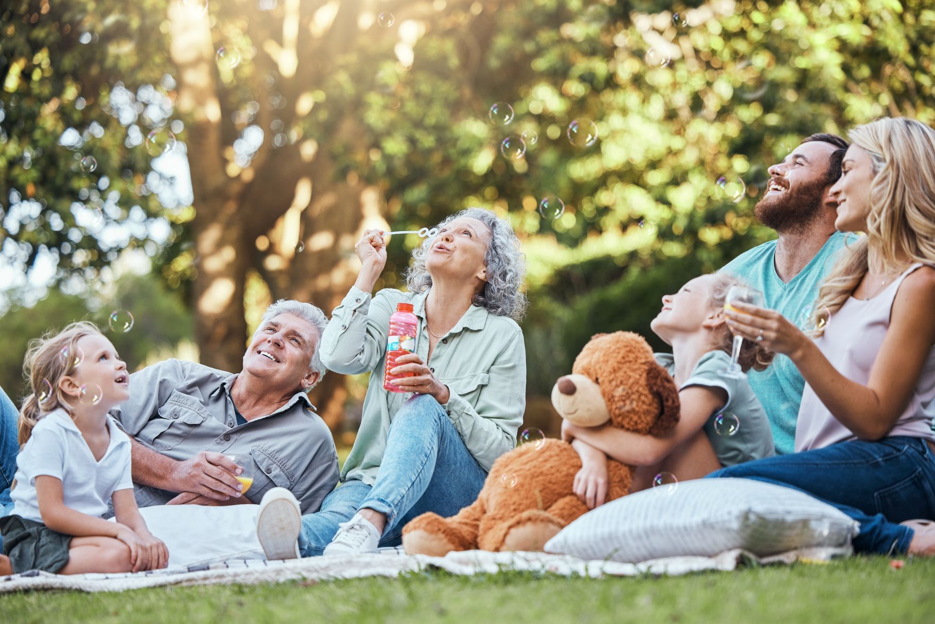 Elderly Grandparents, mother and dad playing outside with excited girl children or kids
